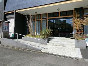 un bâtiment avec des escaliers en face d'un bâtiment dans l'établissement Yurakuan Miyazaki, à Miyazaki