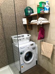 a washing machine in a bathroom with a shower at Luqa Apartment - 5 mins from Airport in Luqa