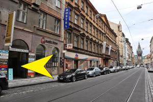 a yellow arrow pointing down a city street with parked cars at A Plus Hostel - Centrum in Prague