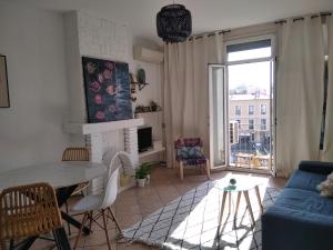 a living room with a table and a blue couch at Grand T2 au COEUR DE VILLE avec VUE SUR QUAIS ET MER in Sète