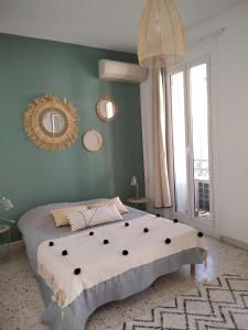 a bedroom with a large bed and a green wall at Grand T2 au COEUR DE VILLE avec VUE SUR QUAIS ET MER in Sète