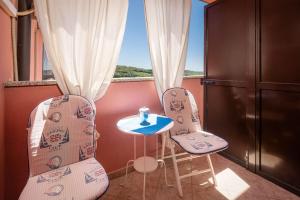 - deux chaises et une table dans une chambre avec fenêtre dans l'établissement Apartments Miri Vrsar, à Vrsar