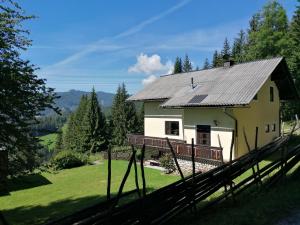 uma casa com um telhado de metal num campo verde em Ferienhaus Stubalpenblick em Salla