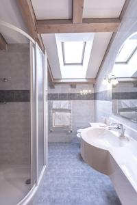 a bathroom with two sinks and a shower at Hotel Garni Schneider in Lutago