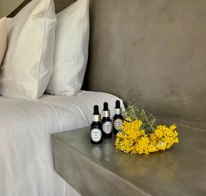 a table with three bottles of wine and flowers on a bed at CASA IB in Peri