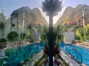 a swimming pool with a mountain in the background at Yangshuo Serene Cove Hotel in Yangshuo