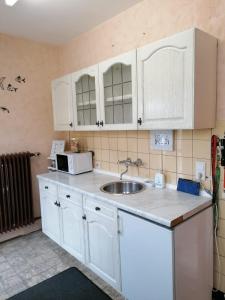 una cocina con armarios blancos y fregadero en Kaisers Ferienhof en Hallenberg