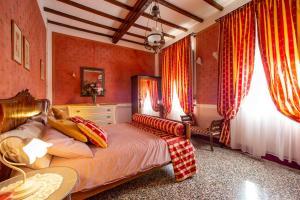 1 dormitorio con 1 cama grande y cortinas rojas en La Ferriera Villa da Sogno, en Castel Focognano