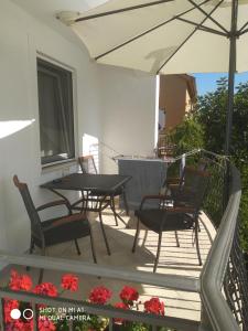 een patio met een tafel en stoelen en een parasol bij Apartment Petar in Sukošan