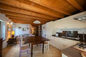 uma cozinha e sala de estar com tecto em madeira em Villa Vitis em Negrar