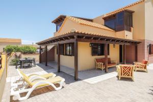 eine Terrasse mit Stühlen und ein Haus in der Unterkunft Casa Maria Granillo in Costa Calma