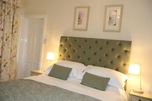 a bedroom with a large bed with two green pillows at The Cordelia in Scarborough