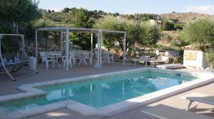 een zwembad met een tafel en stoelen ernaast bij B&B Eyexei Domus in Agrigento