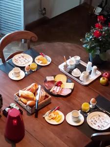 una mesa de madera con platos de comida. en B&B De Mansarde, en Diest