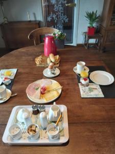 un tavolo in legno con piatti, tazze e piatti di B&B De Mansarde a Diest