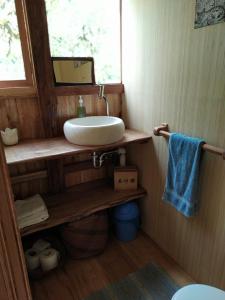 a bathroom with a sink on a wooden shelf at Mindo Eco Suite con Rio y Cascada in Mindo