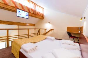 a bedroom with two beds and a tv on the wall at Pensiunea Kronstadt in Braşov +88 photos