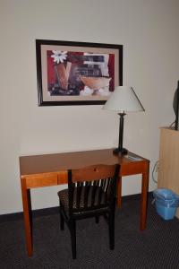 a desk with a chair and a lamp on it at Paola Inn and Suites in Paola