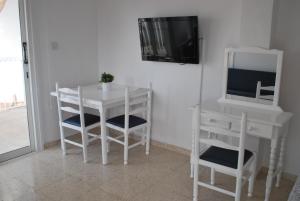a white table and chairs and a television in a room at Flisvos Beach Apartments in Protaras