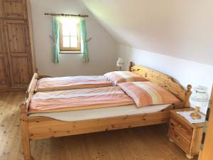 ein Holzbett in einem Schlafzimmer mit Fenster in der Unterkunft Ferienhaus Haring in Kitzeck im Sausal