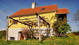 ein Haus mit einer hölzernen Pergola davor in der Unterkunft Ferienhaus Haring in Kitzeck im Sausal