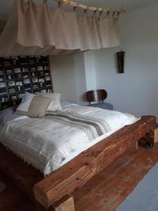 a bed in a room with a wooden bed frame at ZUM SCHEUNENHOF - BAUERNHAUS - Nähe Legoland - Familienfreundlich - Handwerker willkommen in Ichenhausen