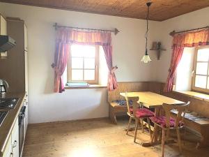 kuchnia ze stołem, krzesłami i oknami w obiekcie Ferienhaus Haring w mieście Kitzeck im Sausal