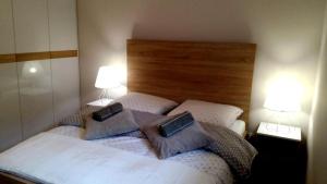 a bedroom with a bed with two pillows and two lamps at Apartament Sun&Fun - Rowy in Rowy