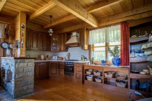a kitchen with wooden cabinets and a stone fireplace at Glisne 69 in Mszana Dolna