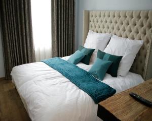 Una cama grande con almohadas blancas y azules. en Z&B Hotel, en Trier