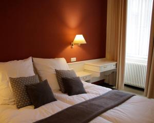 1 dormitorio con 1 cama con sábanas y almohadas blancas en Z&B Hotel, en Trier