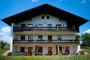 Cette grande maison blanche dispose d'un grand balcon. dans l'établissement Gaestehaus Hofer, à Bad Birnbach