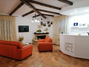 uma sala de estar com duas cadeiras laranja e uma lareira em B&B Villa Isa em Drapia