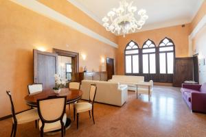 uma sala de estar com uma mesa e um sofá em Doge Morosini Palace em Veneza