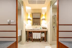 La salle de bains est pourvue d'un lavabo et d'un miroir. dans l'établissement Rawai Palm Beach Resort - SHA Extra Plus, à Rawai Beach