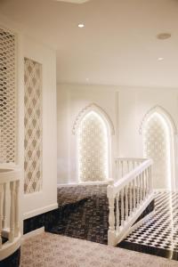 a hallway with two arched windows and a staircase at Hotel de l'amour SHA PLUS in Prakhon Chai