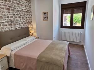 um quarto com uma cama e uma parede de tijolos em Vivienda Turística Cumbre de Pontones em Pontones