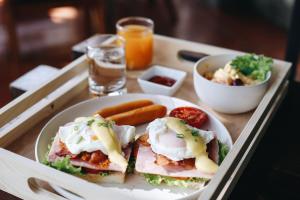 a tray with a sandwich and a bowl of food at Hotel de l'amour SHA PLUS in Prakhon Chai