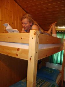 - une femme dans un lit superposé avec un ordinateur portable dans l'établissement Schäferei Bährs, à Neufelderkoog