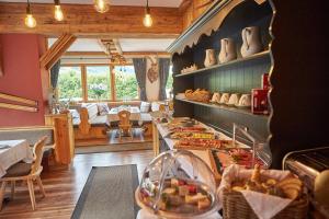 a restaurant with a counter with food on it at Sportpension Enzian in Saalbach-Hinterglemm