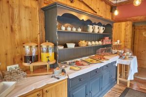 a kitchen with blue cabinets and shelves with food at Sportpension Enzian in Saalbach-Hinterglemm