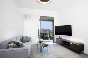 ein Wohnzimmer mit einem Sofa und einem Flachbild-TV in der Unterkunft Stylish Penthouse Apartment Close to Akhziv Beach by Sea N' Rent in Naharija