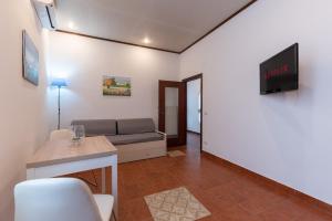 - un salon avec un canapé et une télévision dans l'établissement Evelina in Trastevere, à Rome