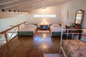 Cette chambre comprend 3 lits et une télévision. dans l'établissement Villa Luna, à Nea Makri