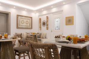 een woonkamer met een tafel en stoelen en een ontbijtruimte bij Hotel Villa Flora in Naxos Chora