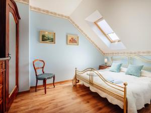 a bedroom with a bed and a chair at Villa Nicolo in Władysławowo