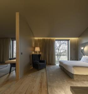 um quarto com uma cama, uma cadeira e uma janela em Monverde - Wine Experience Hotel - by Unlock Hotels em Amarante