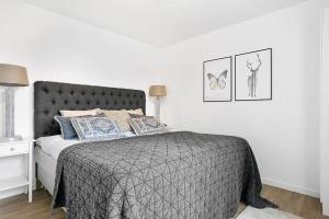 um quarto com uma cama com um edredão cinzento em Hällestrand Village em Strömstad