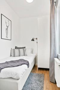 Dormitorio blanco con 2 camas y alfombra en Hällestrand Village, en Strömstad