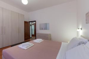 - une chambre blanche avec un grand lit et des serviettes dans l'établissement Evelina in Trastevere, à Rome